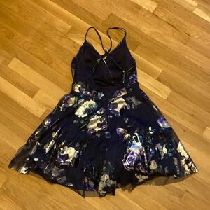 A homecoming dress that’s is dark blue with sliver and greenish blue flowers.